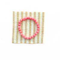Thumbnail for Pink beaded bracelet on a striped fabric background