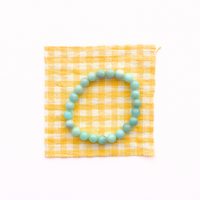 Thumbnail for Turquoise beaded bracelet on a yellow and white checkered pouch