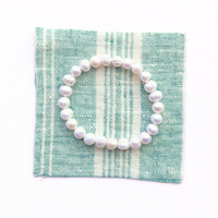 Thumbnail for Pearl bracelet on a green and white striped fabric background