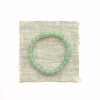 Thumbnail for Green beaded bracelet on a textured white background