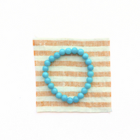 Thumbnail for Blue beaded bracelet on a striped fabric background
